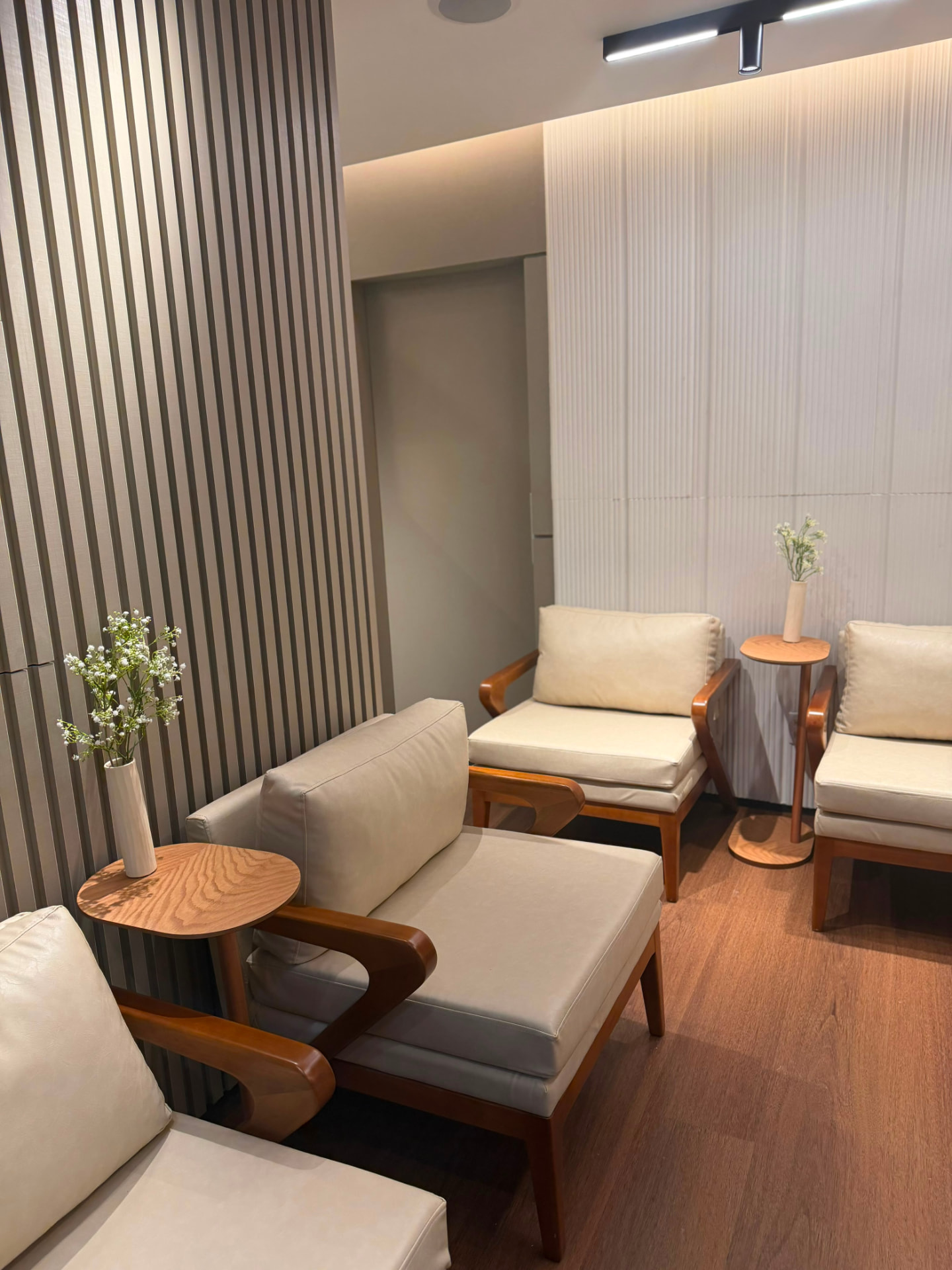 Sala de espera da fiamé clínica, com poltronas claras e madeira